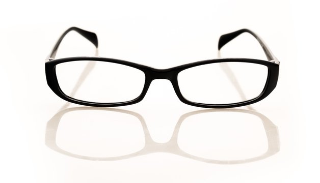 Eyeglasses And Its Reflection Against Light Background