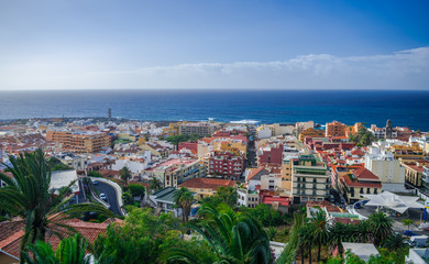 Fototapeta premium Puerto de la Cruz cityscape with Atlantic ocean background and blue sky with sunset light, Tenerife, Canary islands, Spain