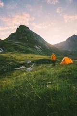 Selbstklebende Fototapeten Camping in den Bergen Mann allein genießt die Sonnenuntergangslandschaft Reiseabenteuer Lifestyle-Konzept aktive Sommerferien mit Zelt in der Wildnis © EVERST