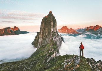 Traveler hiking on mountains ridge over clouds adventure journey traveling outdoor in Norway active vacations sunset Segla mountain - obrazy, fototapety, plakaty