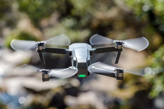 flying quadrocopter on a background of green foliage, close-up
