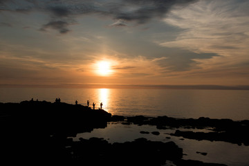 夕暮れの海と釣り人