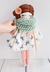 Lovely handmade doll wearing cute white dress, pale pink gaiters and wool scarf
