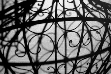 Texture. The shadow of a wrought-iron grille , black-and-white .
