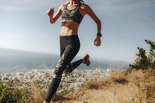 Sportswoman sprinting over rocky trail