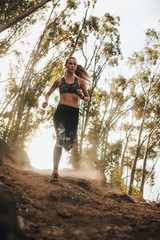 Female runner running on a rocky mountain trail
