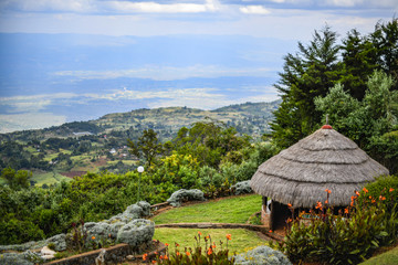 Landscape view from Kerio Escarpment, of traditional African Banda with thatched roof overlooking the Great Rift Valley, Kenya. 