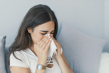 Woman has sneezing. Young woman is having flu and she is sneezing. Sickness, seasonal virus problem...