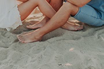 feet of a young couple in love barefoot, on the sand