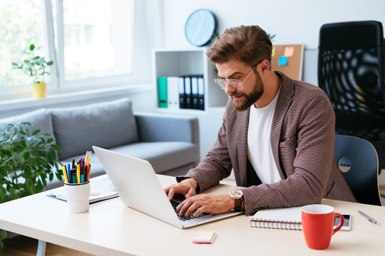 Young startup entrepreneur working on laptop in modern home office. Portrait of businessman during work - Powered by Adobe