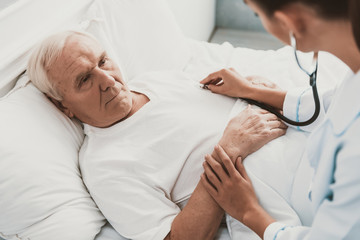 Obraz premium Young Female Doctor Examining Senior Patient