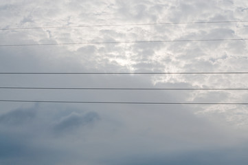 Copper telephone lines or power lines across sky with approaching thunderstorm clouds in south Sweden in July.