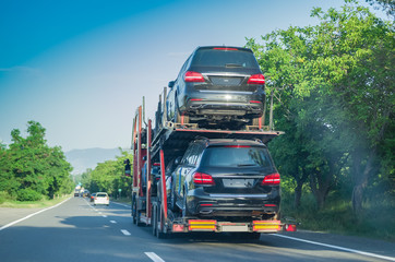 The trailer transports cars on the highway