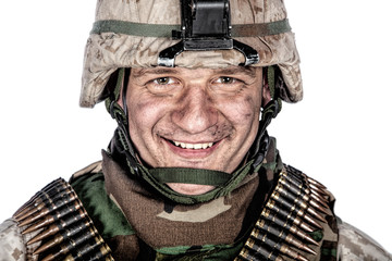 Close up studio portrait of friendly looking marine, military veteran with dirt or soot on face in...