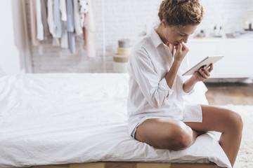 Woman Reading on Tablet at Home