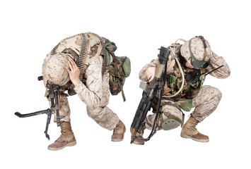 Two army soldiers in camo uniform, armed with assault rifle and machine gun, crouching to ground,...