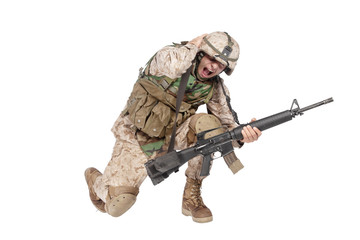 Army soldier in camo uniform, armed with assault rifle and machine gun, crouching to ground, holding helmets and covers ears with hands isolated on white studio shoot Grenade or bomb explosion