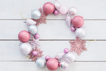 new year festive background. wreath made of decorative toys balls and snowflakes. selection of holiday embellishments. empty negative space concept.