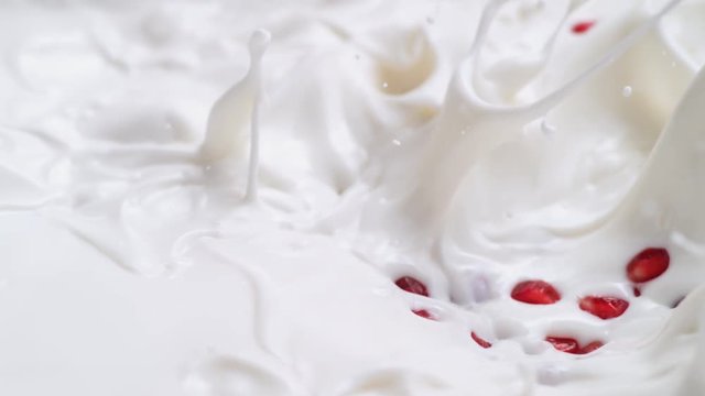 Tossing pomegranate seed in milk. Shot with high speed camera, phantom flex 4K. Slow Motion.