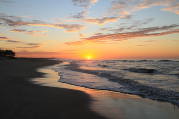 Fototapeta na wymiar Dramatic Tropical Sunrise over Pacific Ocean and Sandy Beach.
