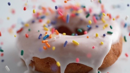 Sprinkling candy chocolate on frosted doughnut. Shot with high speed camera, phantom flex 4K. Slow Motion.