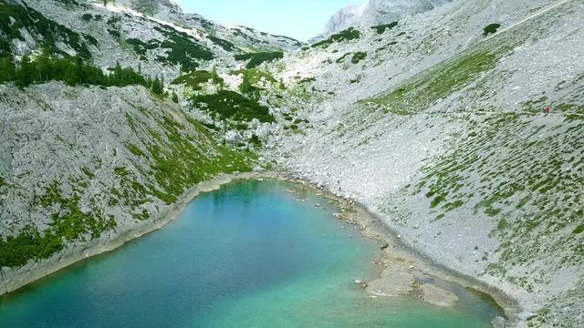 Aerial: Triglav national park in Slovenia, Seven lakes valley. Flying at Ledvica lake. Beautiful valley with lakes between high mountains.
