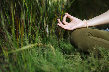 mudra of hand  young woman are folded in a special way into a yoga. Behind a strongly blurred...