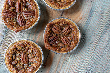 baked mini pecan pies on rustic table © Lynne Ann Mitchell