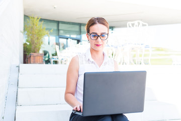 business woman working on laptop on stairs