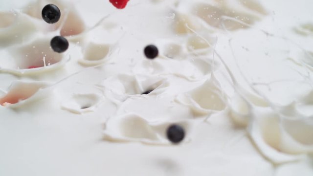 Tossing cut strawberries, blueberries and raspberries in yogurt. Shot with high speed camera, phantom flex 4K. Slow Motion.