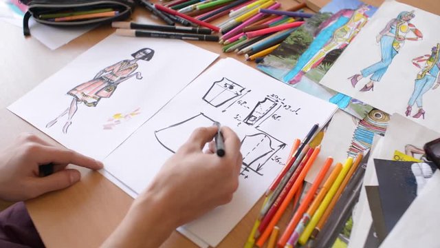 Fashion designer is working on a new collection, making sketches