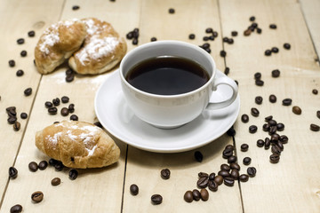 Coffee and croissants for breakfast. Wooden background