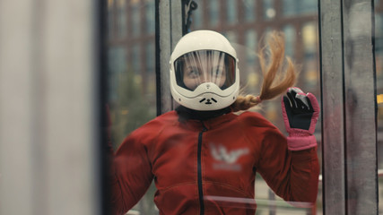 Young skydiver woman getting ready for flight in wind tunnel