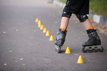 Closeup of kid boy's roller skaters doing twists on asphalt