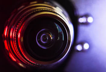 The camera lens and light reddish-purple color . Close up. Horizontal photography