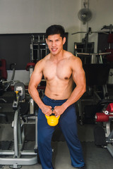 Fototapeta na wymiar Asian muscular men are lifting weights in the gym.