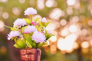 artificial flowers in beautiful small pot and beautiful bokeh background
