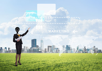 Camera headed woman standing on green grass against modern cityscape