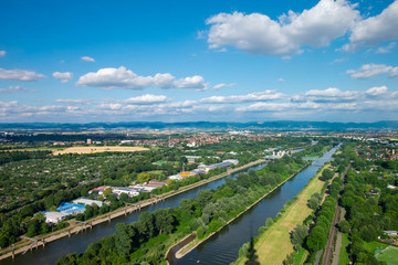 The aerial view of the area around Manheim city from above, with Neckar river in the center and hills in the background. Shot on a sunny summer day from the telecommunication tower. - obrazy, fototapety, plakaty