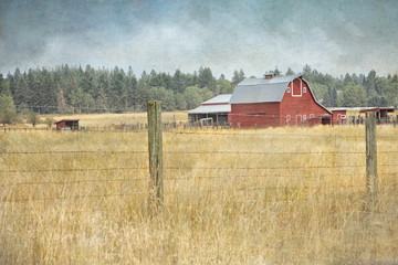 Textured photograph of a red barn in a field in the country © Janice