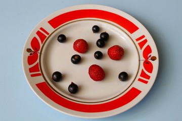 Plate of black currants and strawberries