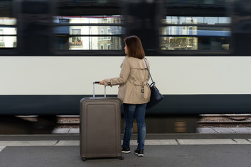 A girl is wating a train in a trian station at Geneva, Switzerland.