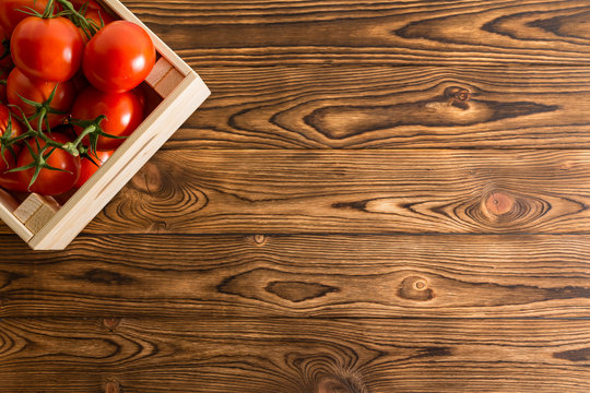 Juicy ripe red tomatoes in a wooden crate