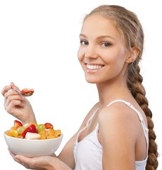 Attractive young woman holding salad and smiling at camera