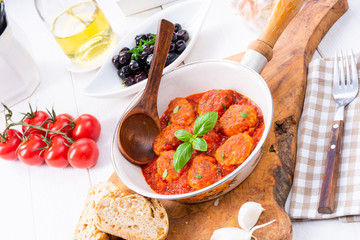 Baked mini meatballs in tomato sauce with basil