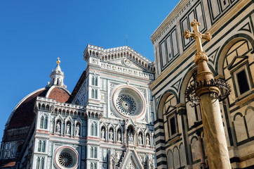 Facade of the famous basilica of Santa Maria del Fiore (Saint Mary of the flower), cathedral of Florence, Italy, with the medieval baptistery and a christian cross