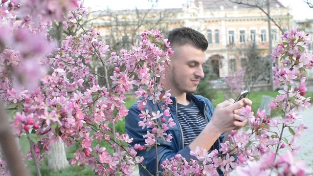 Mobile Cell Phone in the Hands of a Man - chating wrighting sms - in a city park