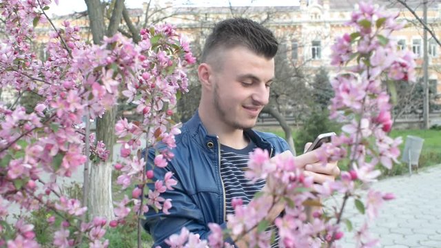 Mobile Cell Phone in the Hands of a Man - chating wrighting sms - in a city park