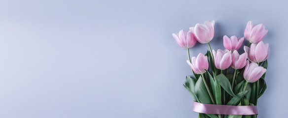 Bouquet of pink tulips flowers on blue background. Waiting for spring. Flat lay, top view