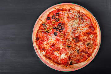 Mixed pizza Italian food with chicken, tomatoes, mushrooms, ham, salami, olive and cheese on dark wooden background